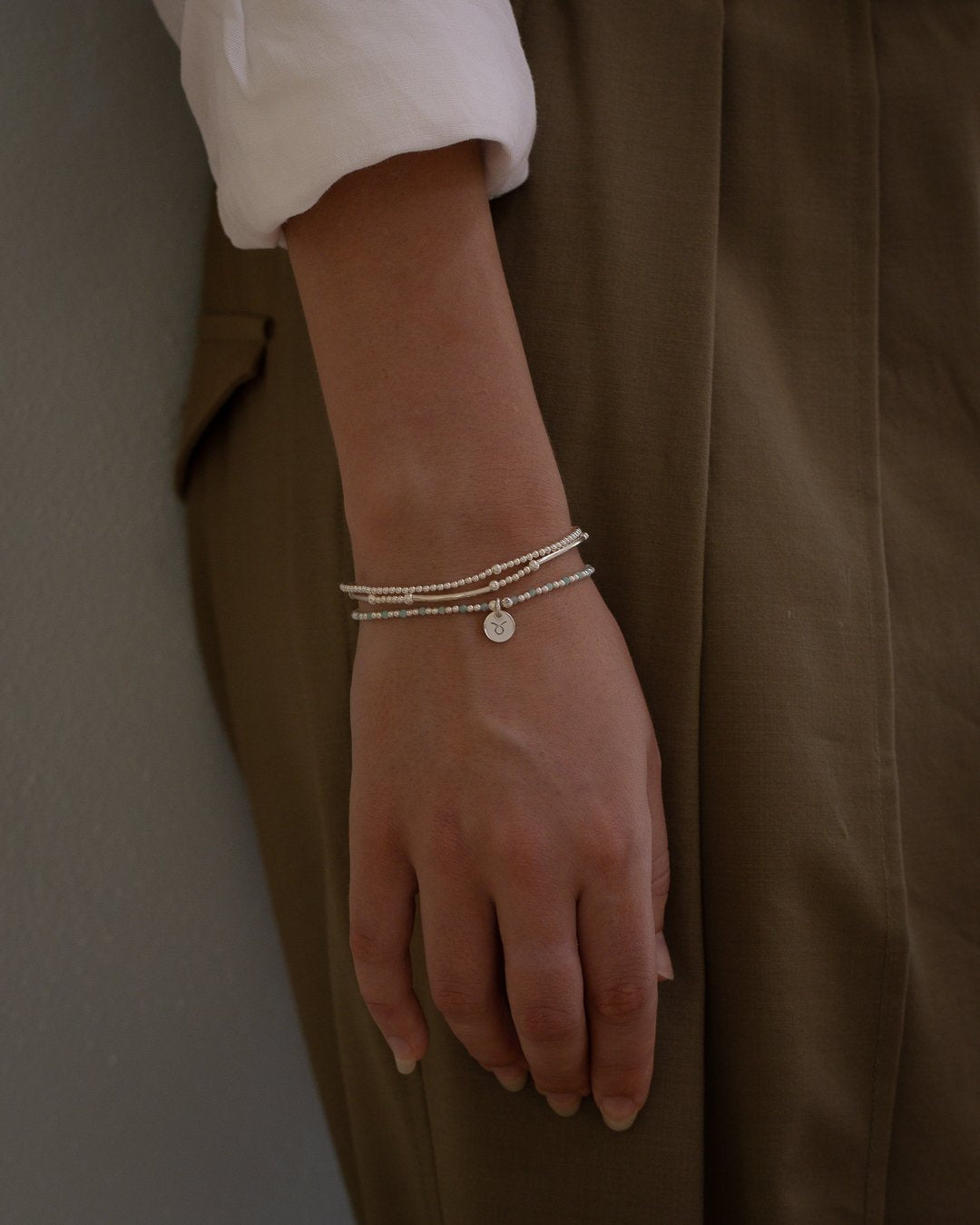 Zodiac Stack worn on wrist with sterling silver bracelets and Libra charm by Petals Australia