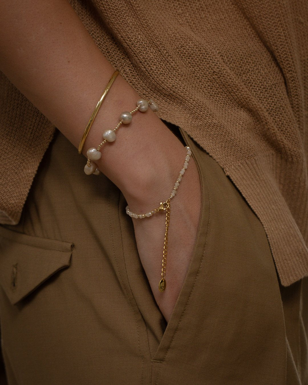 The Champagne Stack by Petals Australia worn on wrist with gold cuff and pearl bracelet